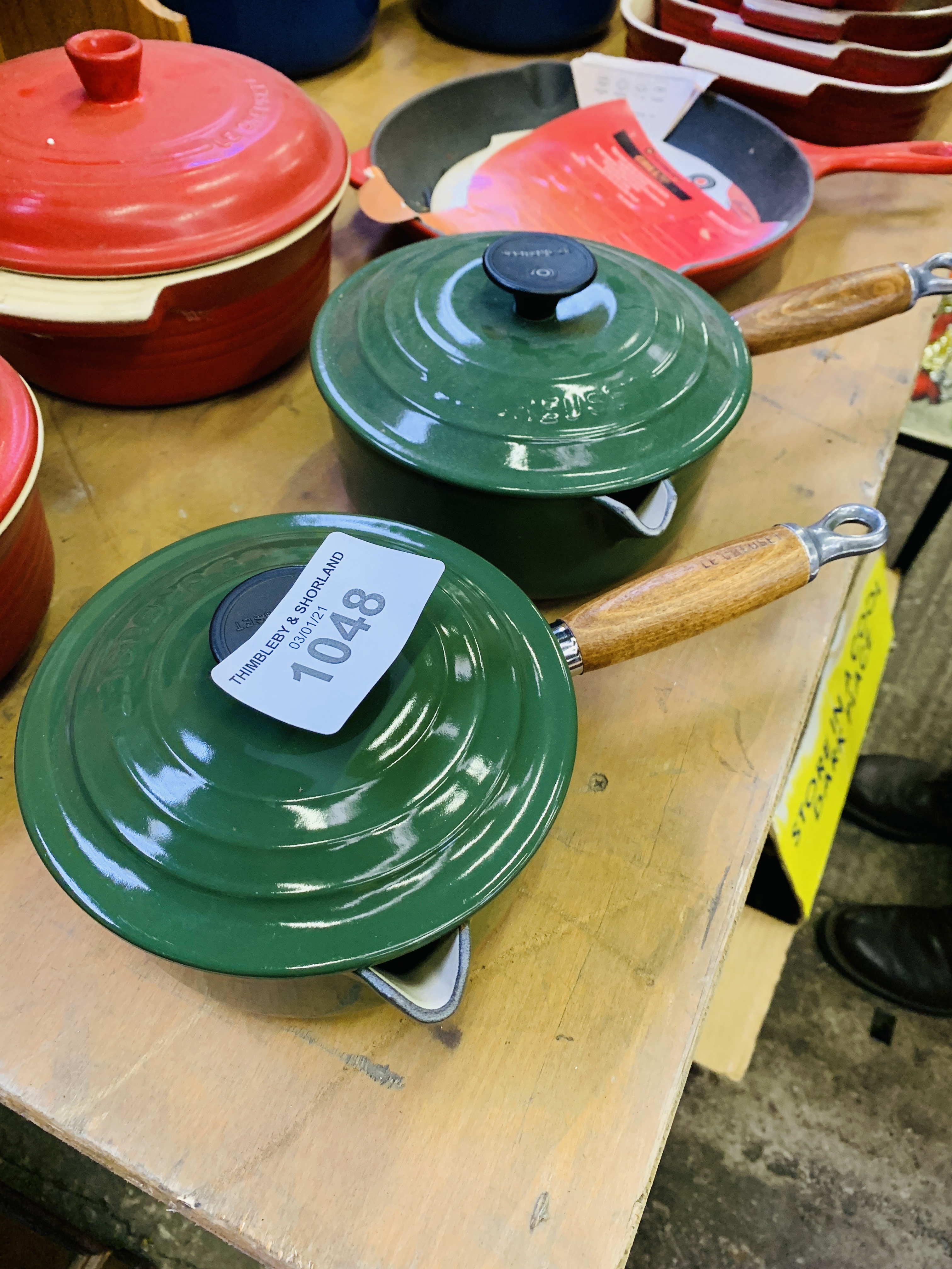 Two green Le Creuset pans.