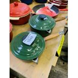 Two green Le Creuset pans.