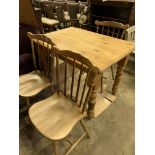 Pine kitchen table together with three Windsor-style chairs.
