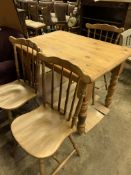 Pine kitchen table together with three Windsor-style chairs.