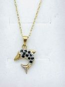 9ct gold stone set dolphin pendant on 9ct gold chain.