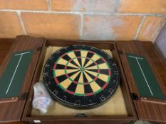 Dartboard in a wall mounted wooden case with darts.