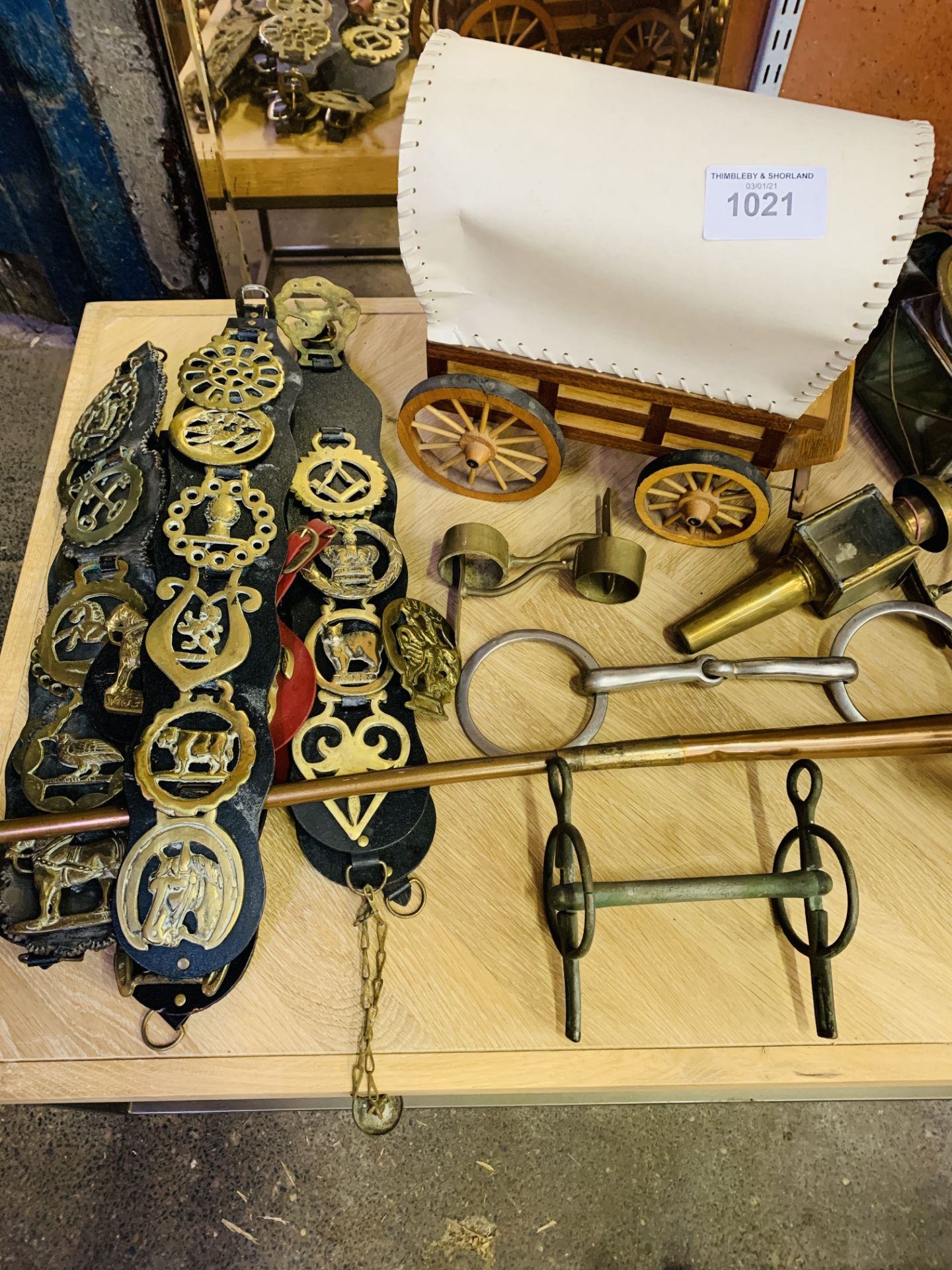 A quantity of mainly horse-related brass items and a blowlamp.