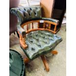 Green buttoned leather upholstered swivel Captain's chair on casters.