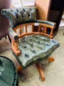 Green buttoned leather upholstered swivel Captain's chair on casters.