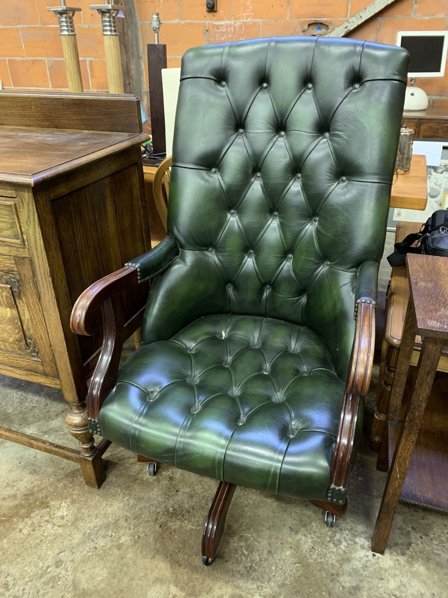 Green buttoned leather upholstered swivel chair.