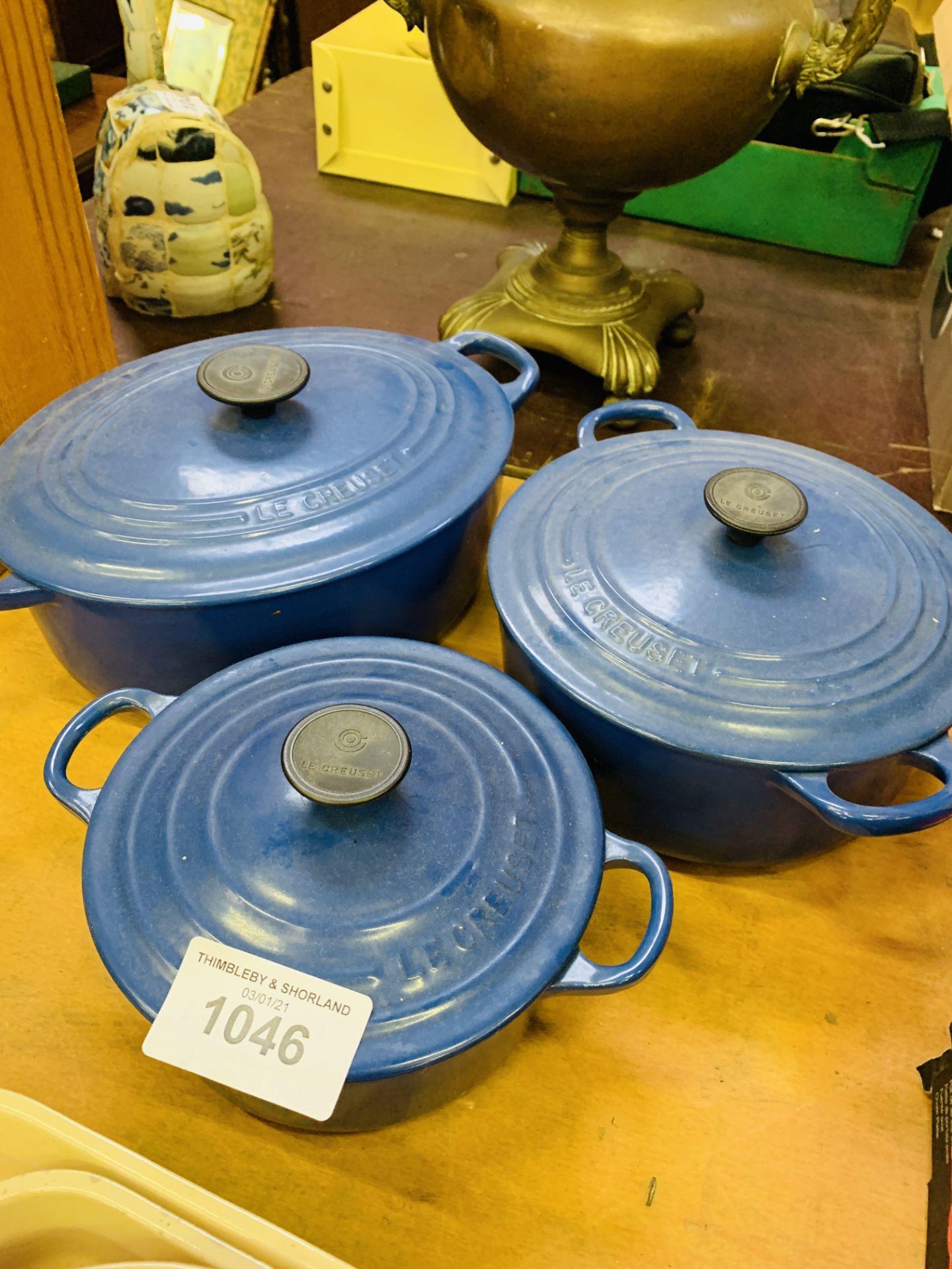 Three blue Le Creuset casserole dishes.
