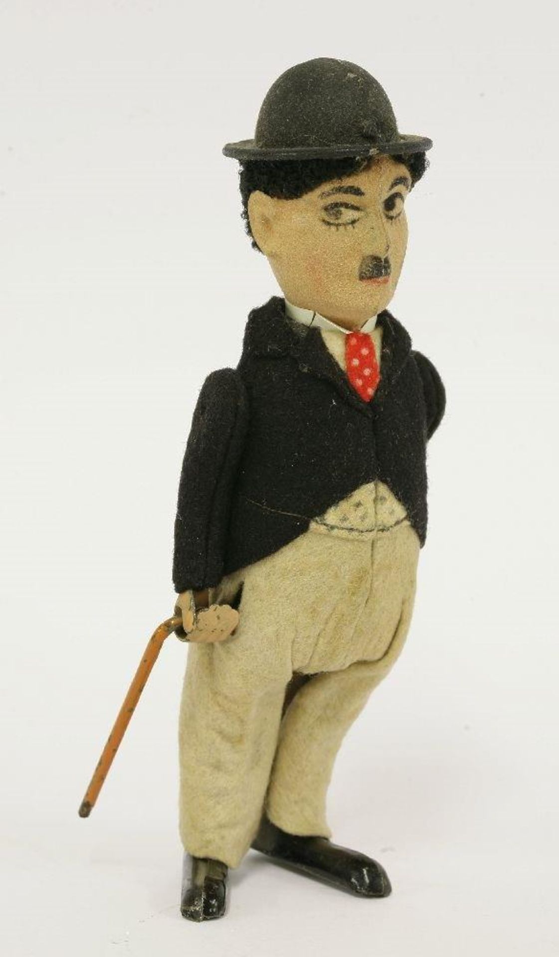 A Schuco Charlie Chaplin tinplate clockwork figure, in a black felt jacket with grey trousers and