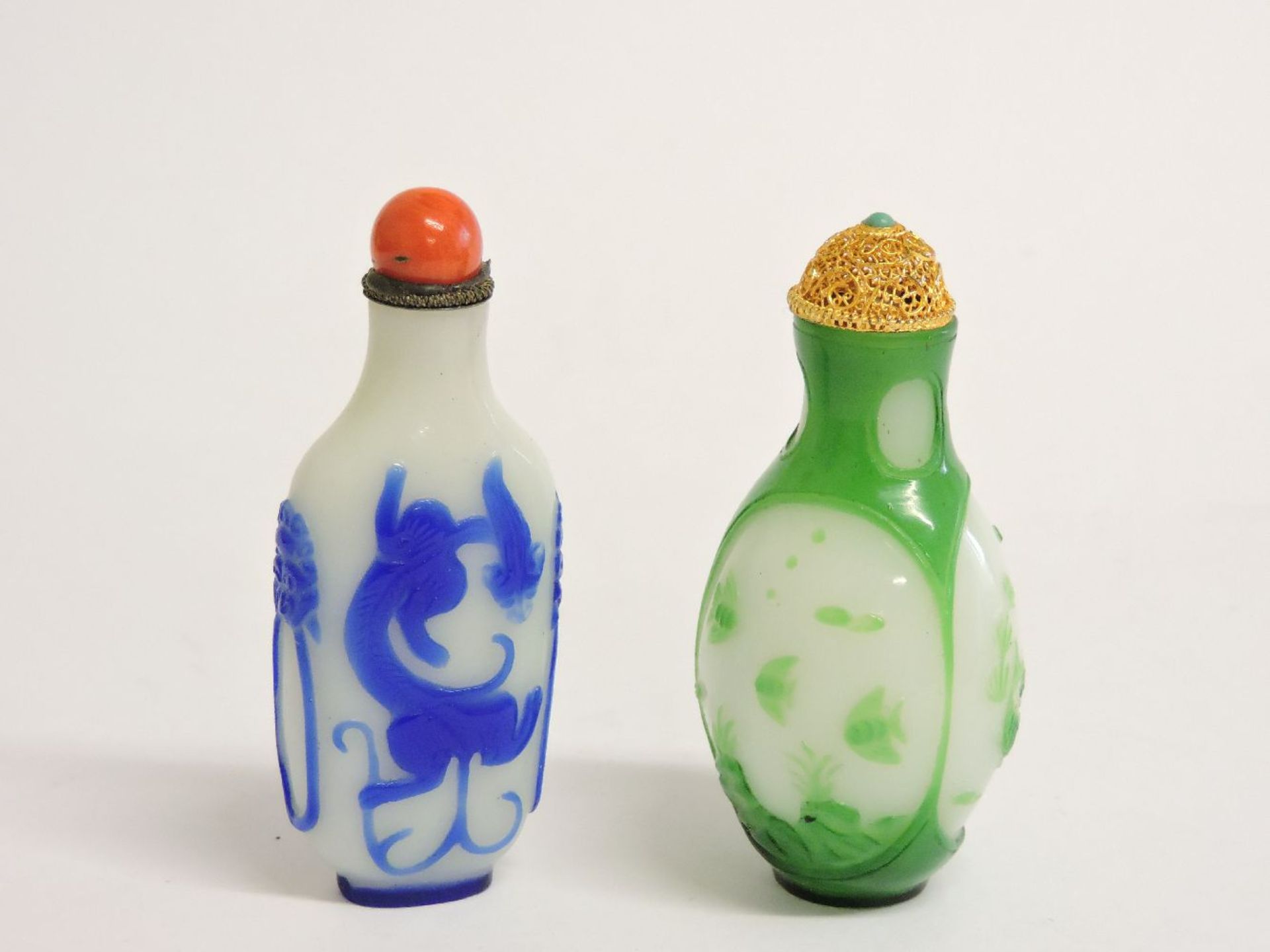 Two Chinese overlaid glass snuff bottles and stoppers, blue and green, 7cm high