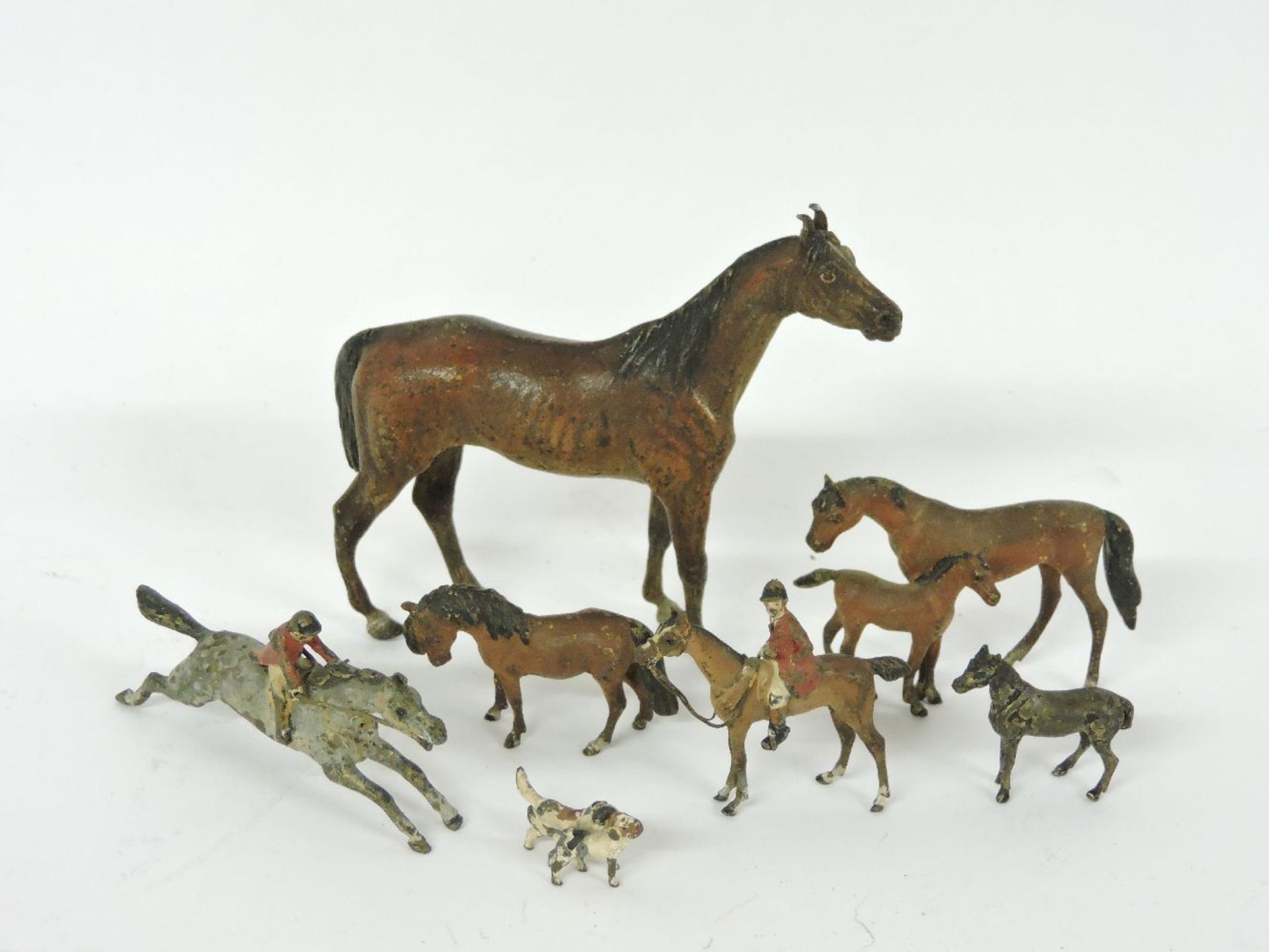 A cold painted bronze figure of a horse, together with further cold painted bronzes of a huntsman,