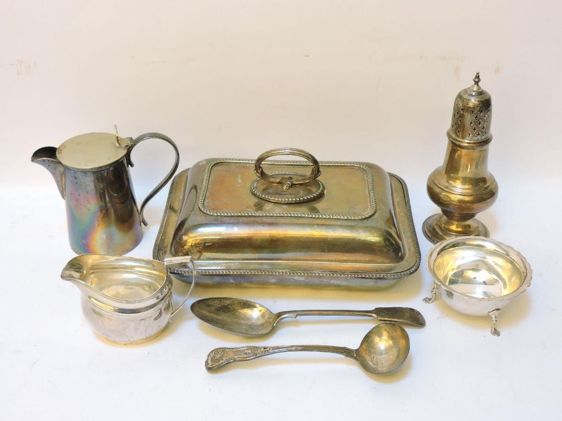 A Georgian silver cream jug, a William IV silver ladle, a silver sugar bowl and sifter, a silver