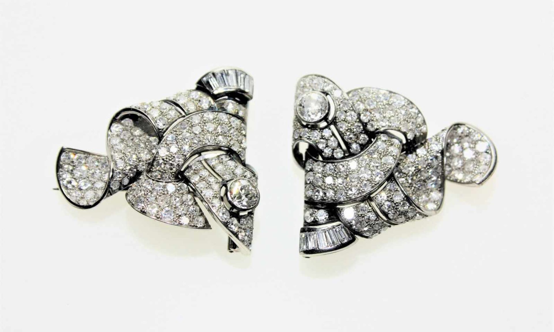 Zwei identische Clipbroschen ca. 750/f, zwei Diamanten in Brillant-Altschliff zus.ca. 1,20 ct in