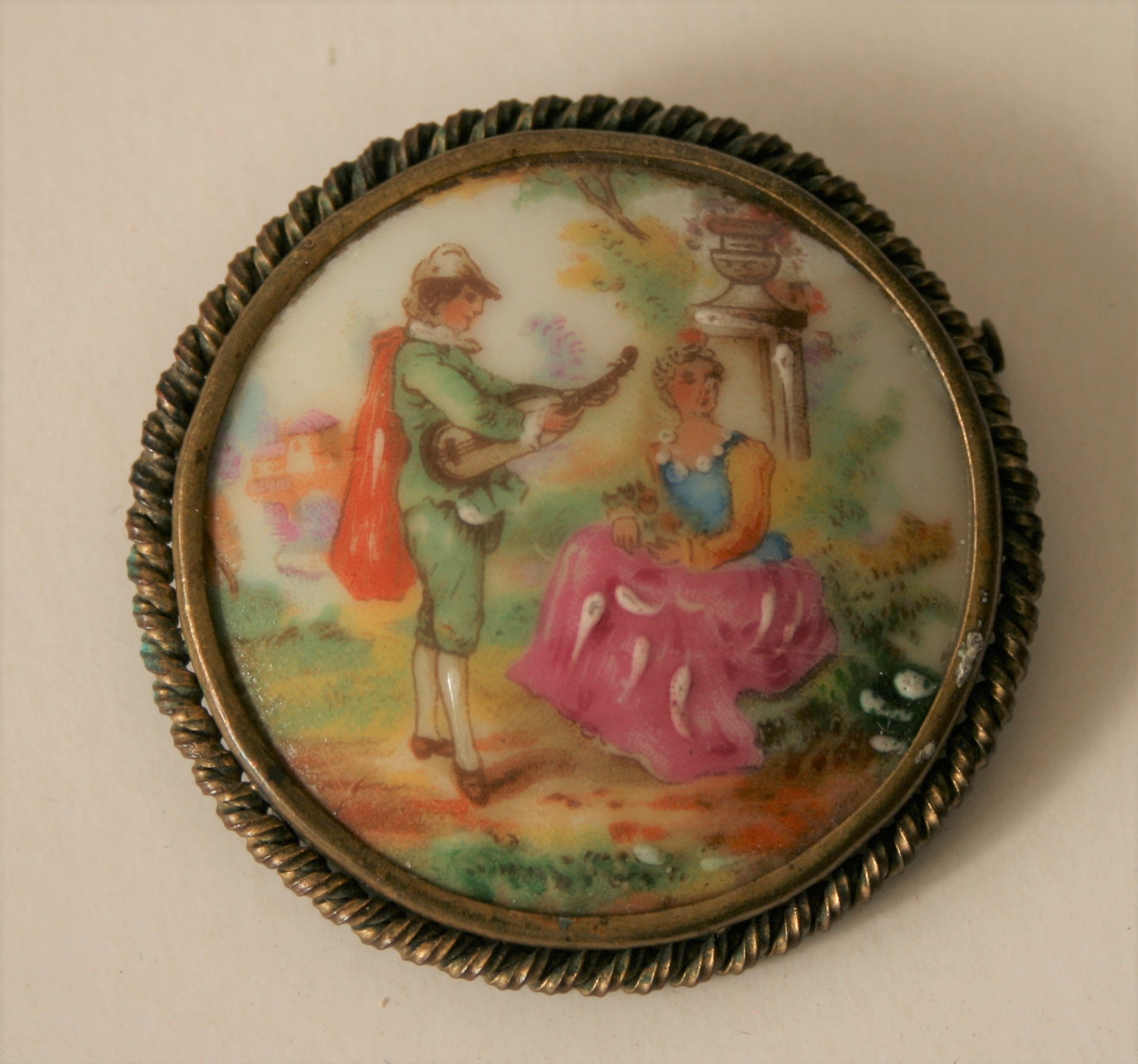 Broche en porcelaine de Limoges gainée d'une torsade en laiton, décor peint à la [...]