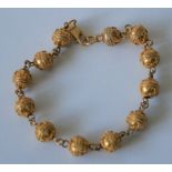 Bracelet en or 18 ct composé d'une succession de 12 boules gravées de motifs [...]