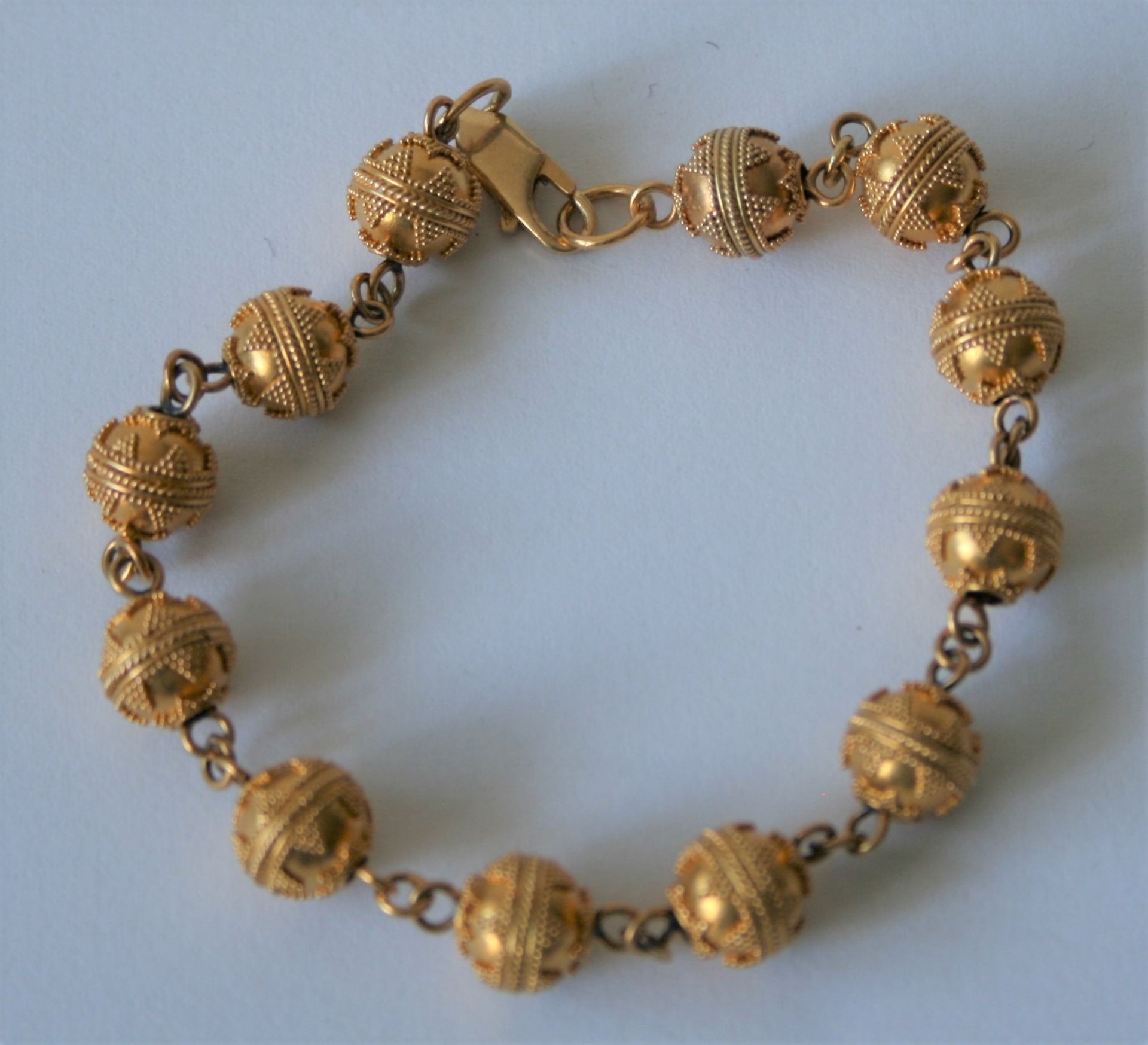 Bracelet en or 18 ct composé d'une succession de 12 boules gravées de motifs [...]