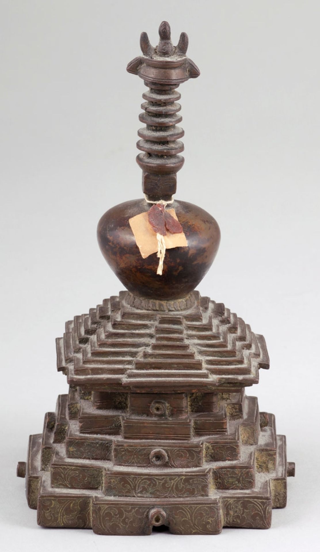 Stupa auf ThronstufenNepal, 18. Jahrhundert. Bronze. H. 20,5 cm. Zweiteilig gegossen. Mit Blüten und