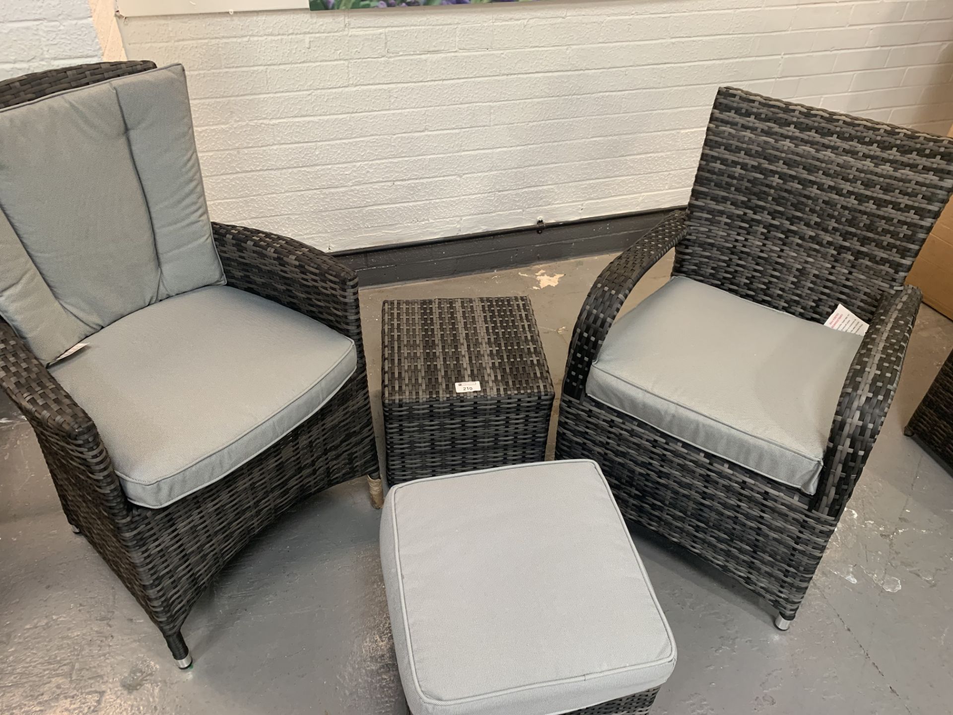 A pair of Grey Maze Rattan arm chairs 1 missing back cushion and 2 footstools - only 1 x cushion