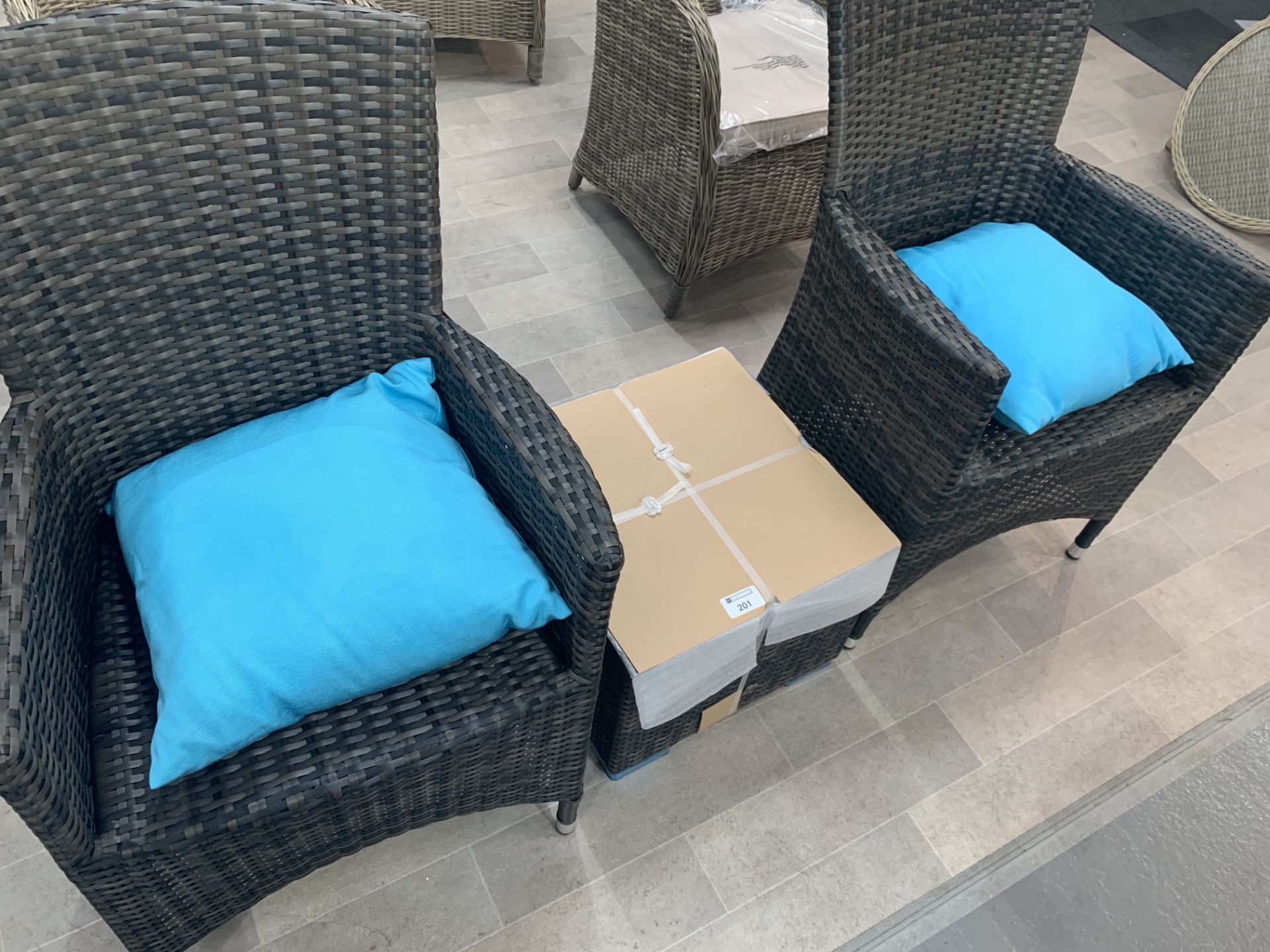 A Pair of Maze Rattan Cushion Arm chairs with matching glass top table