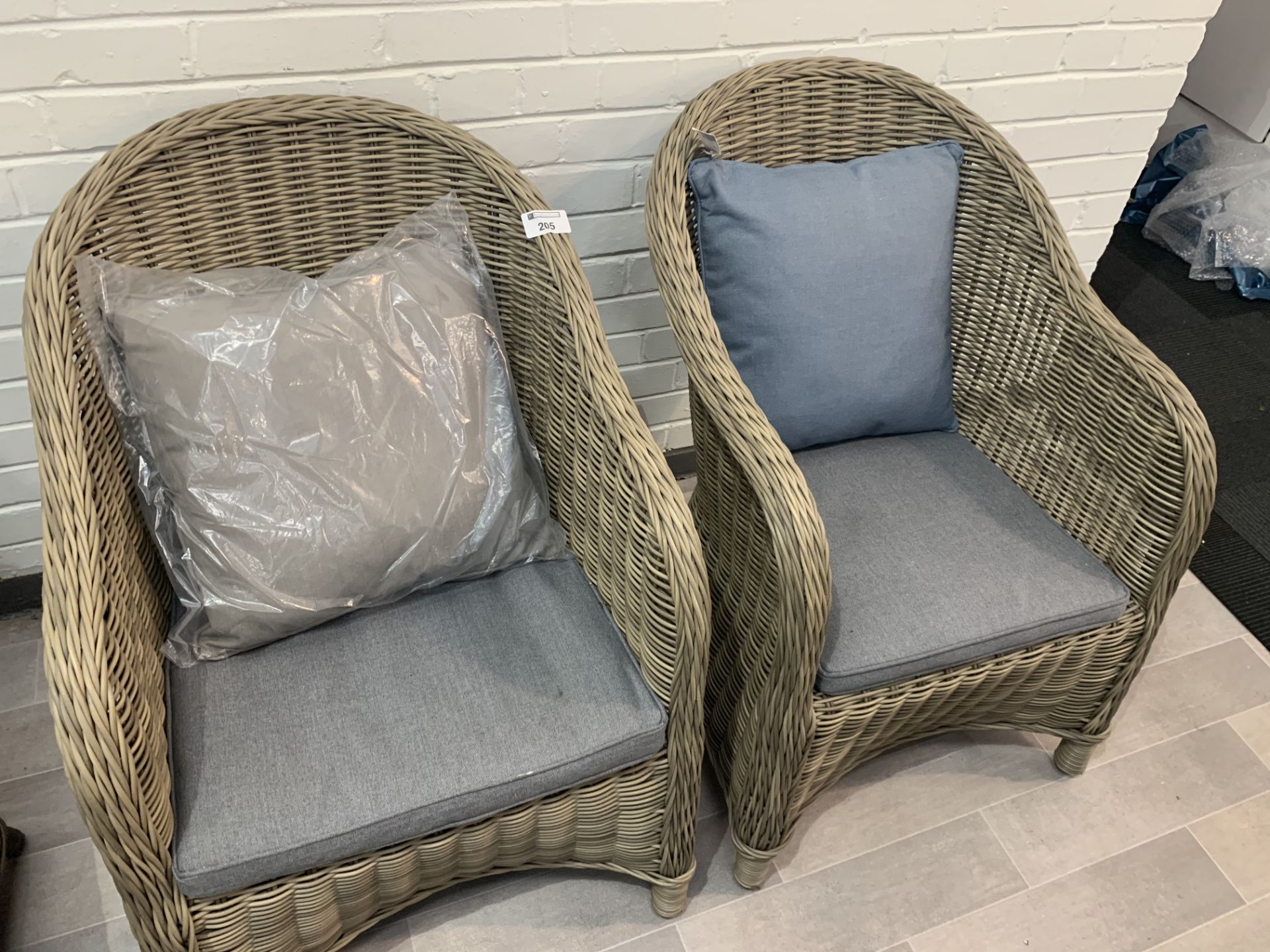 A Pair of Maze Rattan curved back woven arm chairs with cushions