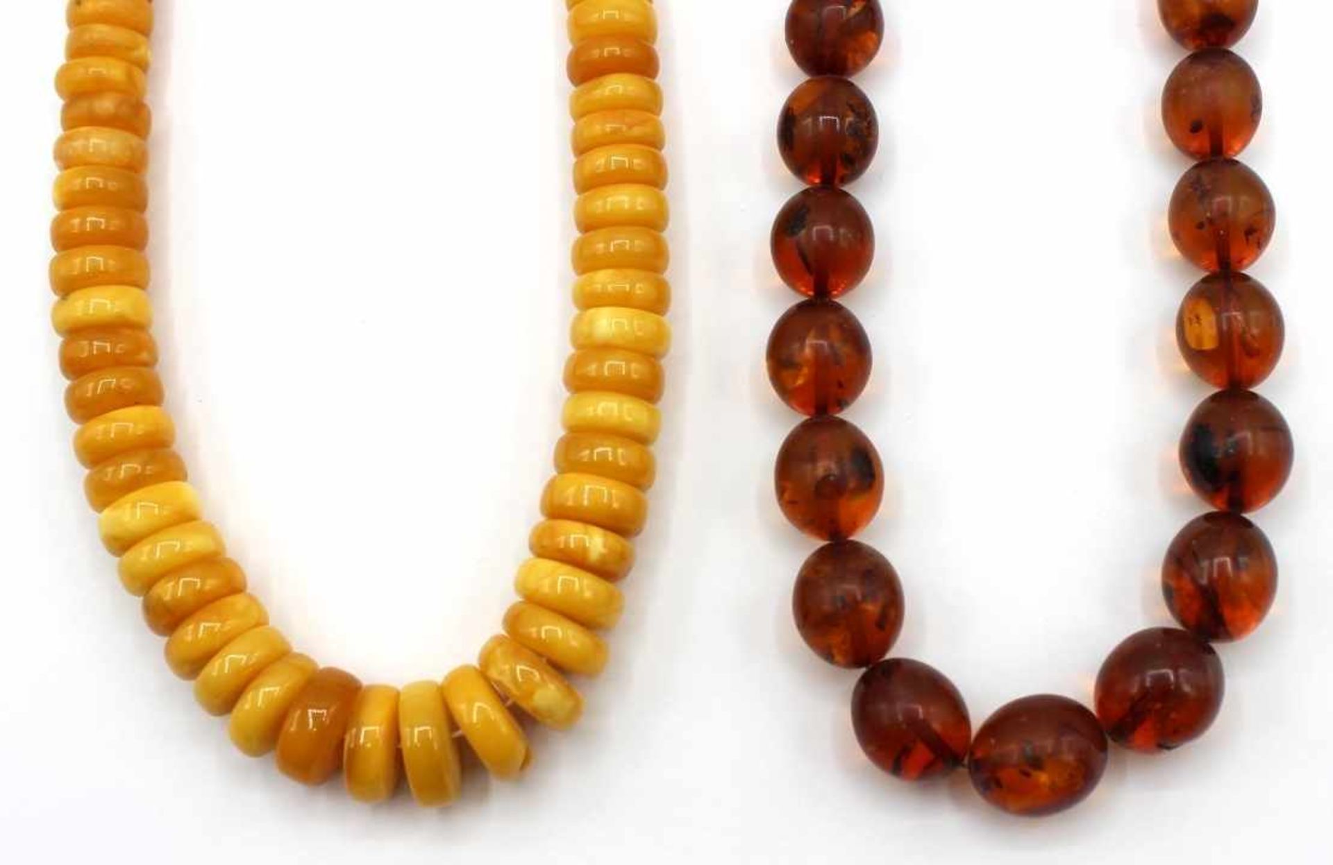 Paar Halsketten Bernstein, geschnittene Ringe und ovale Perlen mit natürlichen Einschlüssen,