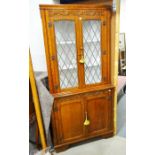 An oak corner cupboard fitted glazed leaded doors