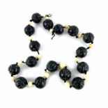A Chinese carved black jade and ivory bead necklace