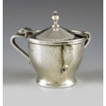 A E Jones, Chester 1922, an Arts and Crafts silver mustard pot, planished, three handled ogee cup fo