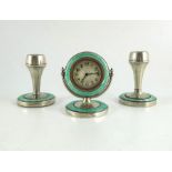 A pair of Art Deco silver and enamelled candlesticks and a timepiece