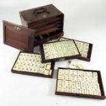 A Chinese Mahjong set in hardwood case, bone and bamboo, in five drawers, retailers label for Kwang
