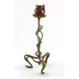 An Art Nouveau brass and copper candlestick