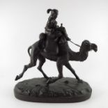 A Black Forest wooden carving of a traveller riding a camel