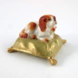 A Royal Worcester miniature figure of a dog on a cushion