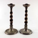 A E Jones, a pair of Arts and Crafts silver plate and oak candlesticks