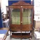 An Edwardian bow front corner cabinet, quarter gla