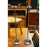 A pair of adjustable metal wig stands, on octagonal