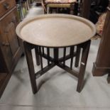 A Persian style brass topped table on folding base