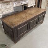 A carved oak coffer, three panelled front on carve