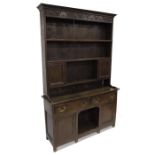 A George III oak and pine dresser and rack, the three bay base with central kneehole flanked by cupb