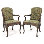 A pair of two George I style walnut open armchairs