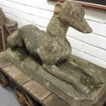 A cast stone model of a greyhound on lozenge base.