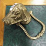 A brass door knocker modelled as a dog's head