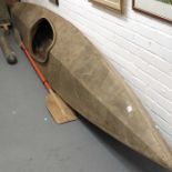 A wooden Kayak with paddle.