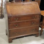 A George III oak bureau, three graduated drawers,
