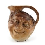 Robert Wallace Martin for Martin Brothers, a stoneware face jug, 1899, modelled in high relief to