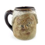 Robert Wallace Martin for Martin Brothers, a relief moulded stoneware characterful face tankard,