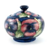 William Moorcroft, a Pansy on blue pot and cover, circa 1928, squat ovoid form, impressed marks