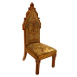 A Gothic Revival walnut carved chair, the pointed foliate top with needlework upholstery to the back