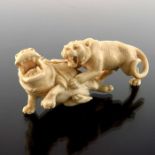 A 19th century Japanese ivory okimono of a tiger attacking a hippo