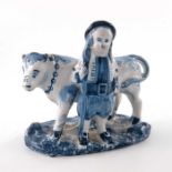 A Delft figure of a farmer and cow