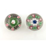 Clichy, two patterned millefiori paperweights, one central white and red cane, surrounded by green c